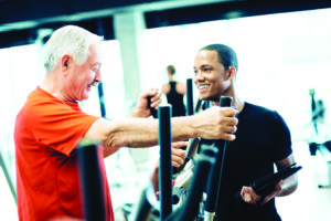 Personal Trainer Helping Senior man in GYM